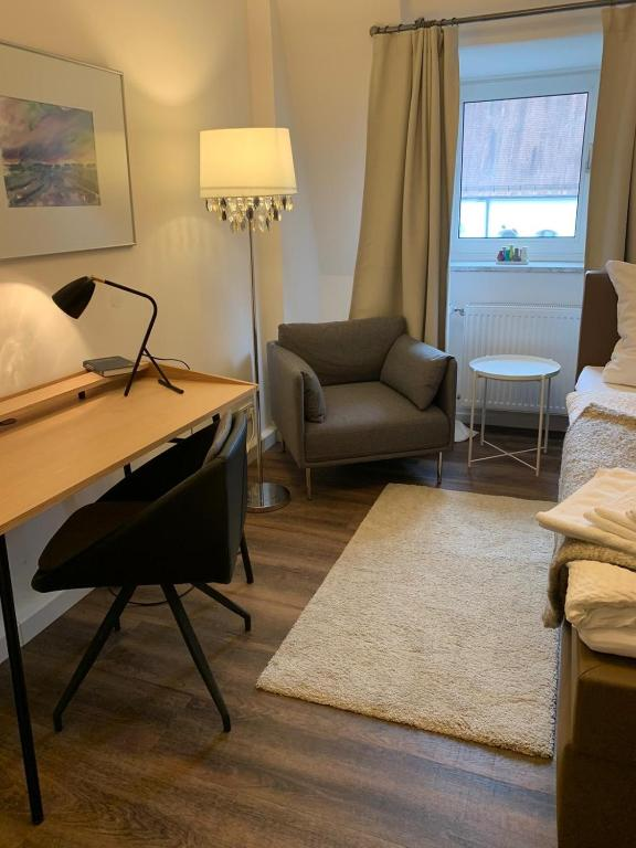 Gästezimmer mit Schreibtisch, Sessel und Bett