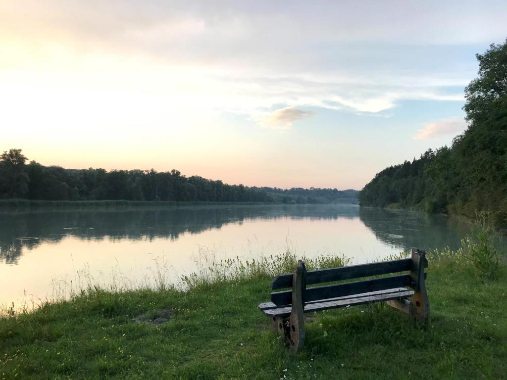 Bank am Ufer des Inn in der Abenddämmerung